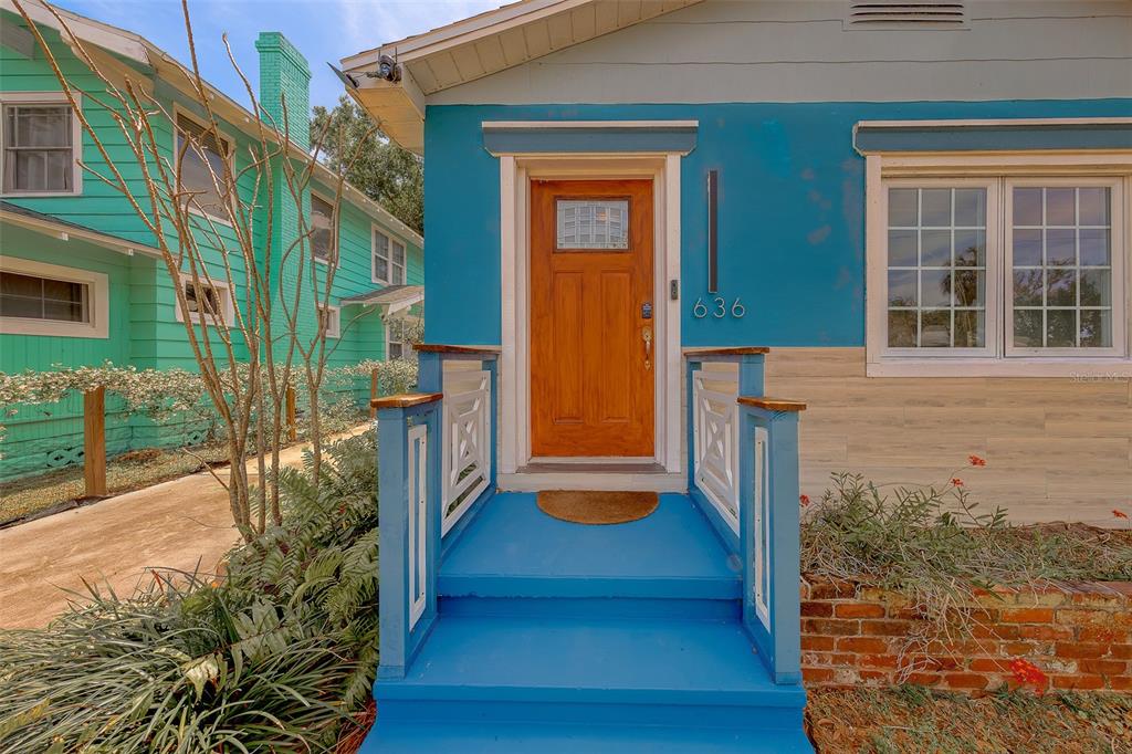 The exterior of a house features a blue front door, wooden steps, and light-colored siding — 636 37TH AVENUE S, ST PETERSBURG, FL
