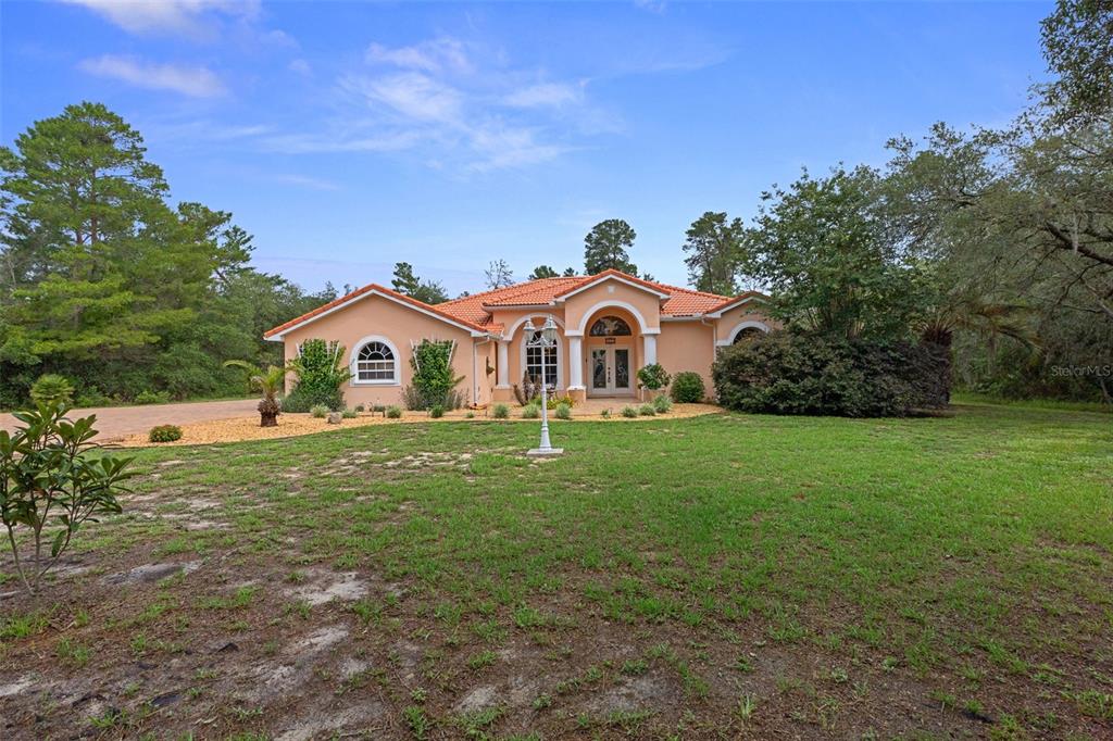 A single-story peach-colored house with a tile roof sits on a grassy lot — 4525 W ALAMO DRIVE, BEVERLY HILLS, FL