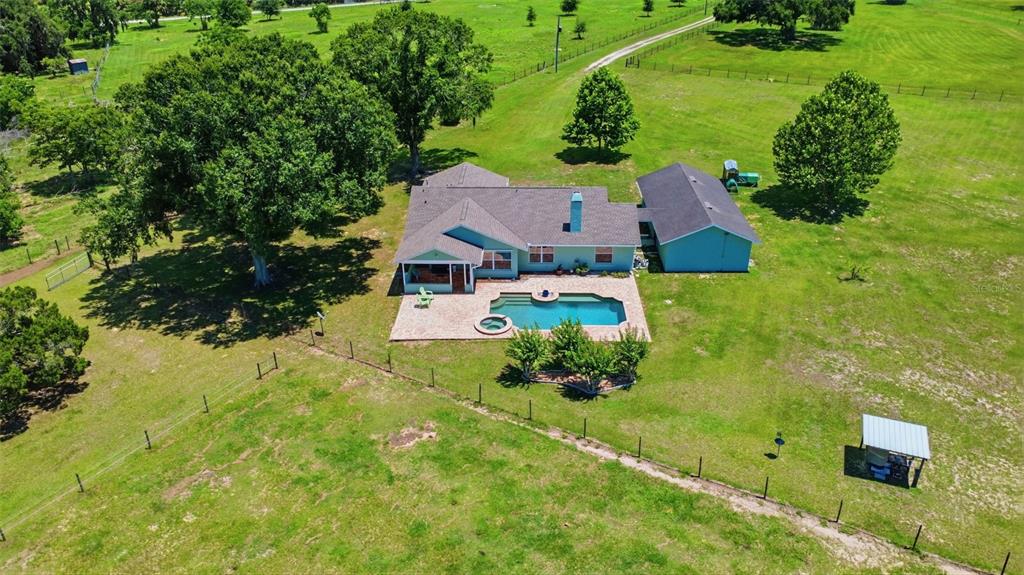 An aerial view shows a light blue house with a pool and a detached garage — 1200 N HART ROAD, GENEVA, FL