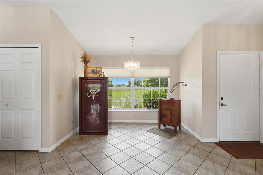 A tiled entryway features a large gun safe, a wooden cabinet, and a window view — 1200 N HART ROAD, GENEVA, FL