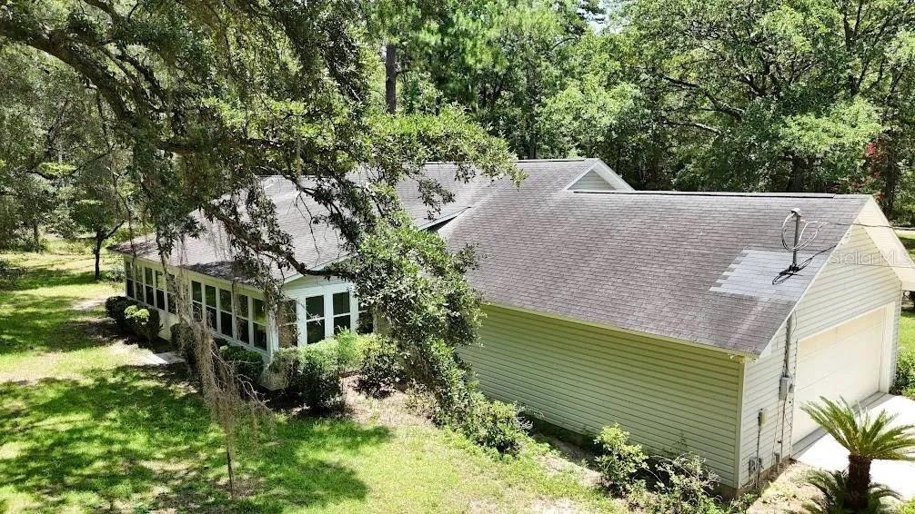 An elevated view of a light-colored house with a garage and a large sunroom — 6794 STURMER PLACE, TALLAHASSEE, FL