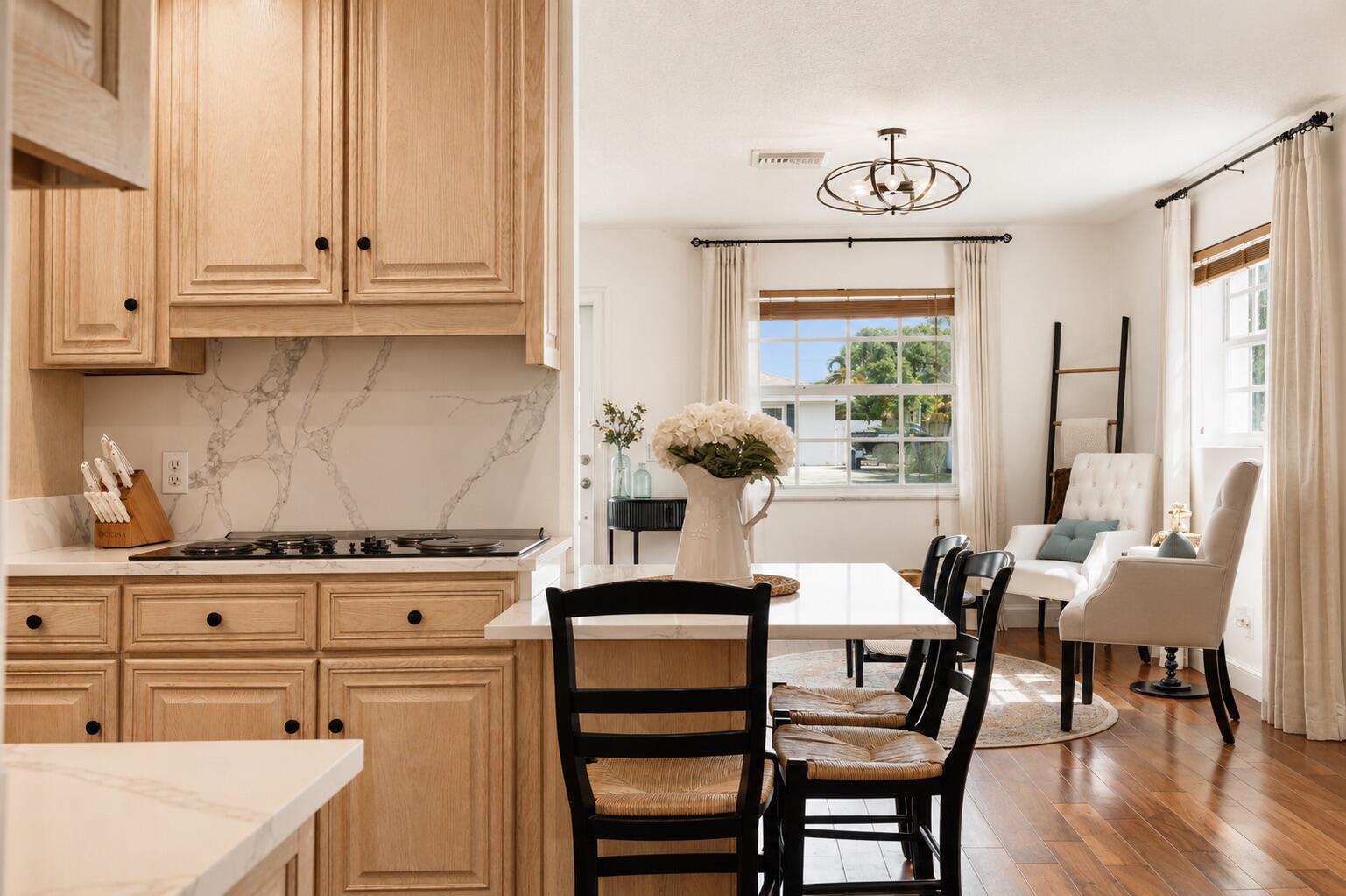 A kitchen with light wood cabinets and marble countertops opens into a bright dining area — 7416 Overlook Drive, Lake Worth FL 33467, LAKE WORTH, FL
