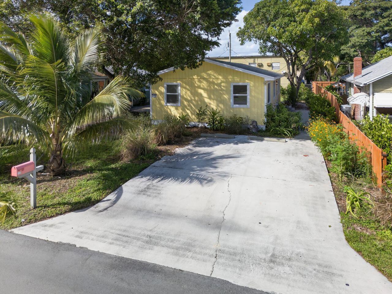 A yellow house with a concrete driveway and a palm tree in the front yard — 117 NE 8th Street, Pompano Beach FL 33060, POMPANO BEACH, FL
