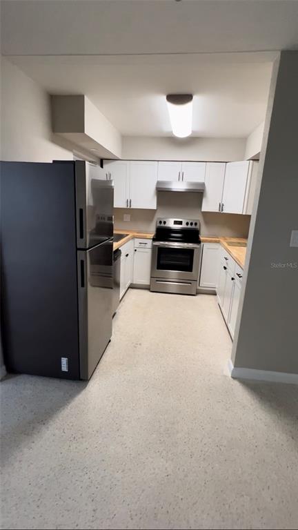 A kitchen features white cabinets, stainless steel appliances, and light-colored flooring — 2618 LAKESHORE CIRCLE, PORT CHARLOTTE, FL