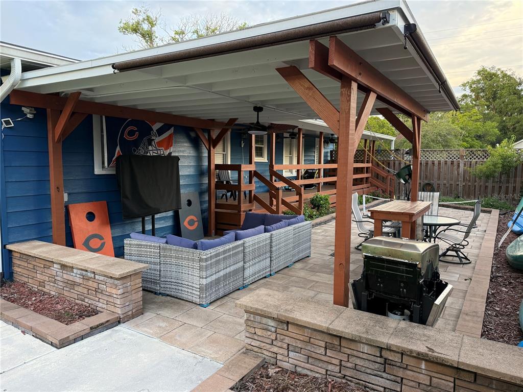 A covered patio features a wicker sectional, a dining set, a grill, and cornhole boards — 1510 SANFORD AVE, SANFORD, FL