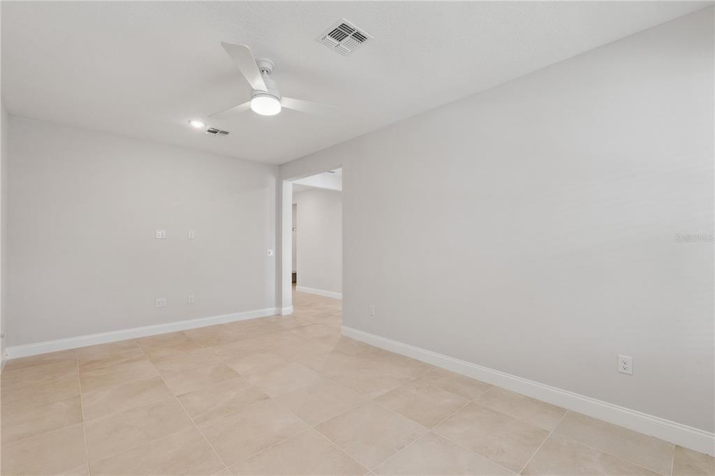 An empty room with light-colored tile flooring, gray walls, and a ceiling fan — 13129 FARO COURT, WINTER GARDEN, FL