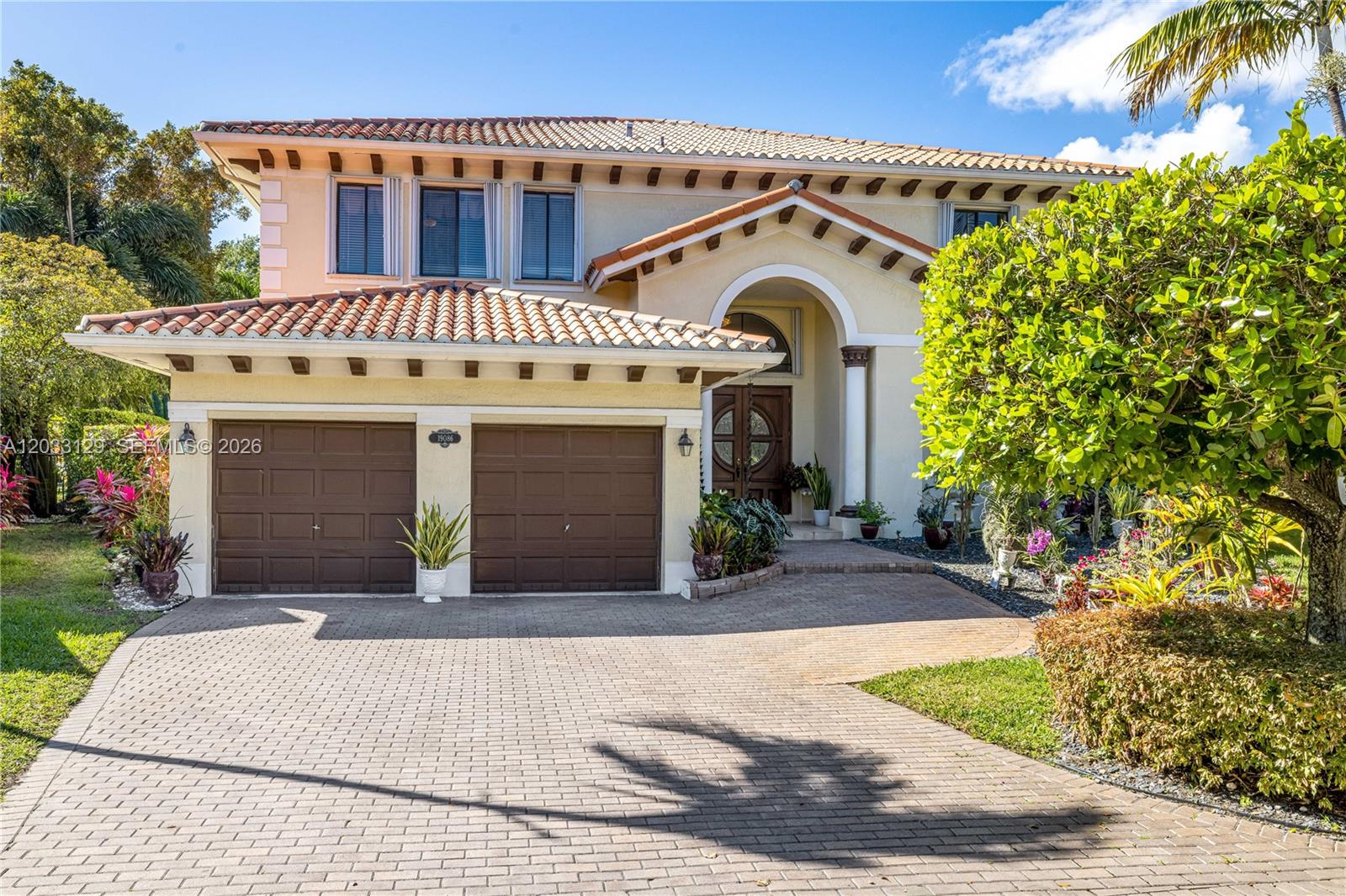 A two-story stucco house features a tile roof, a two-car garage, and a paved driveway — 19086 SW 76th Ave # 0, Cutler Bay FL 33157, CUTLER BAY, FL
