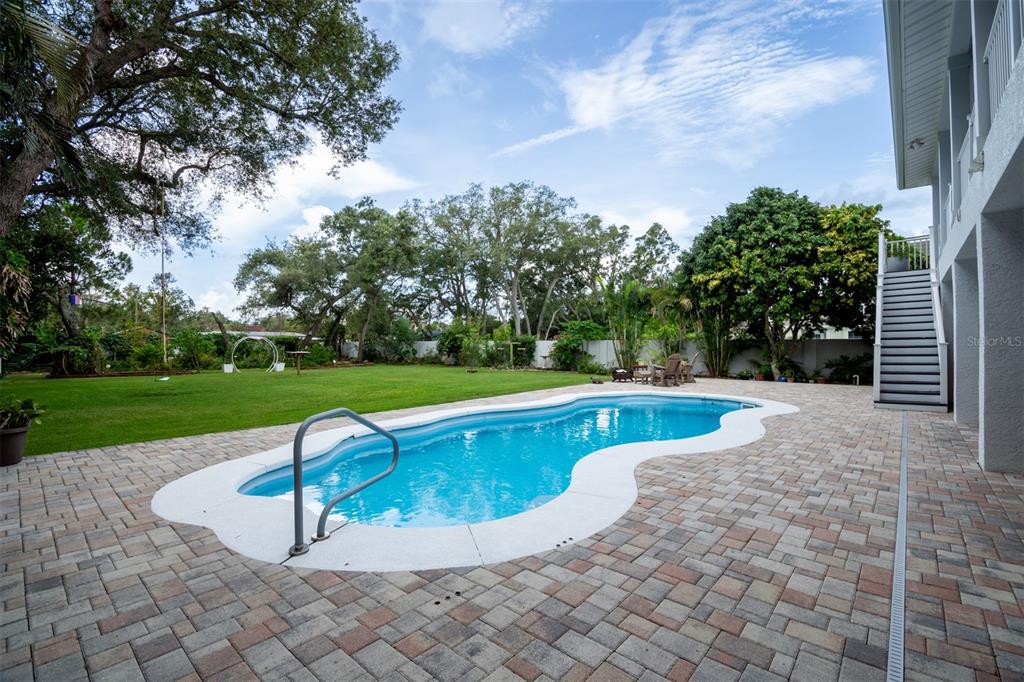 An aerial view shows a white two-story house with solar panels and a front staircase — 1605 GULF ROAD, TARPON SPRINGS, FL