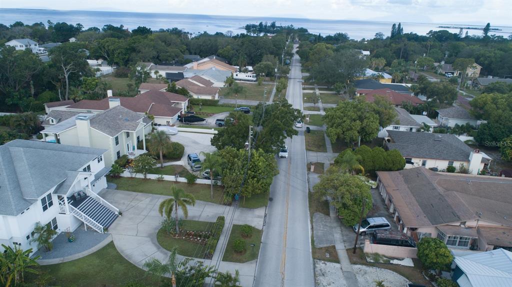 A backyard features a kidney-shaped swimming pool, a brick paver deck, and a grassy lawn — 1605 GULF ROAD, TARPON SPRINGS, FL
