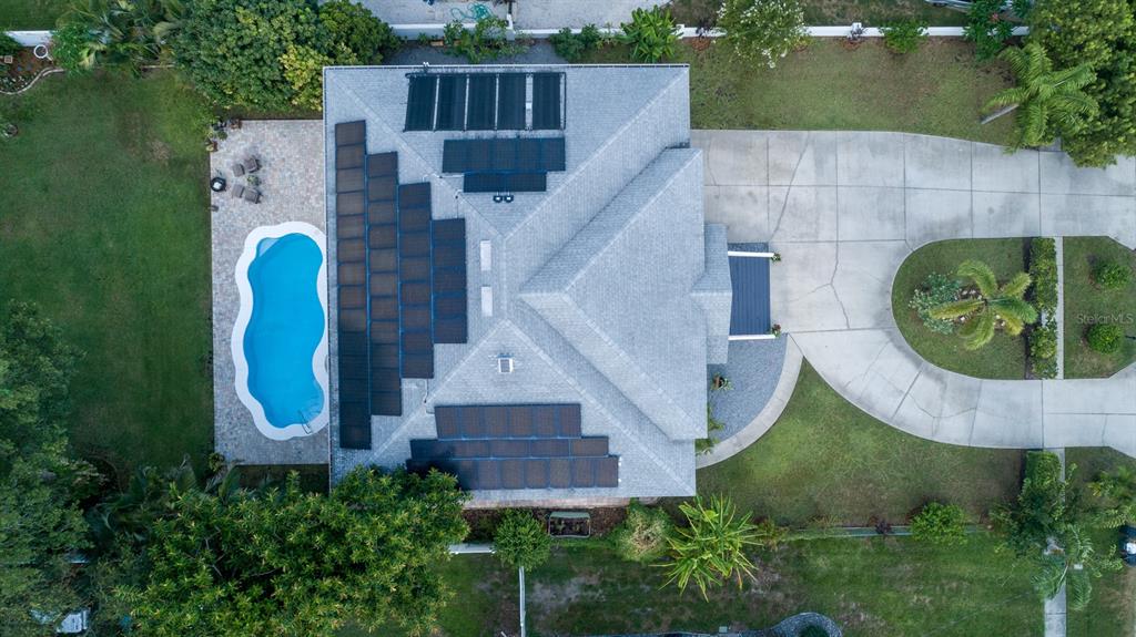 A modern kitchen features a large white quartz island, stainless steel appliances, and hardwood floors — 1605 GULF ROAD, TARPON SPRINGS, FL