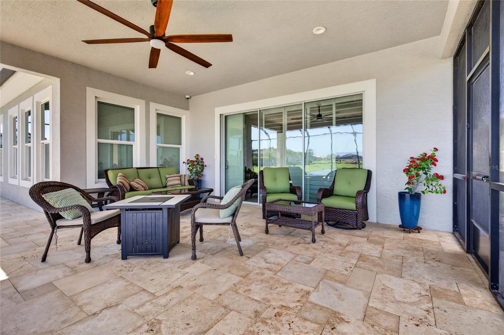 A screened-in swimming pool patio overlooks a lake with a stone deck and metal railing — 305 AQUAMARINE WAY, DAYTONA BEACH, FL