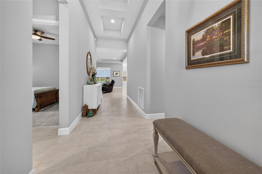 A covered patio features stone flooring, wicker furniture, a fire pit, and a ceiling fan — 305 AQUAMARINE WAY, DAYTONA BEACH, FL