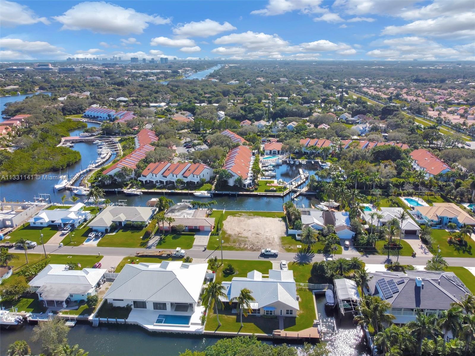 An aerial view shows waterfront residential homes, a vacant lot, and a canal with boats — 2400 Edward Rd, Palm Beach Gardens FL 33410, PALM BEACH GARDENS, FL