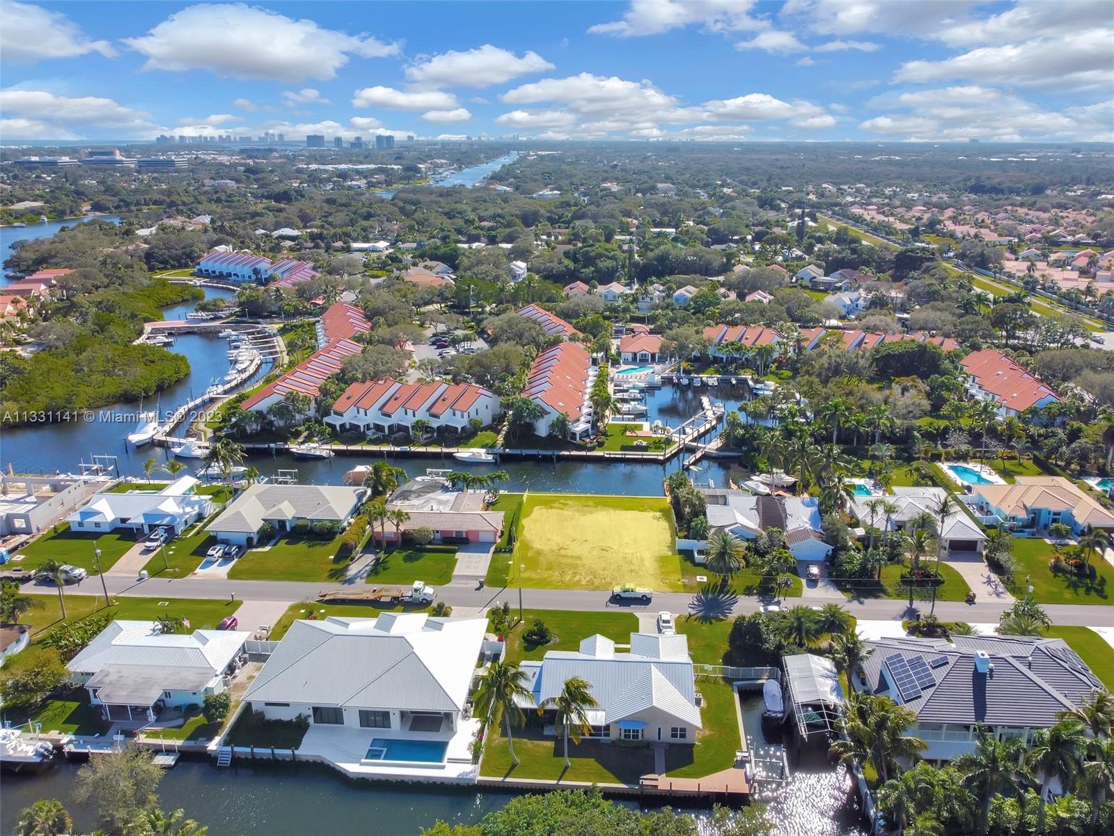 An aerial view shows waterfront homes with pools and boat docks along a canal — 2400 Edward Rd, Palm Beach Gardens FL 33410, PALM BEACH GARDENS, FL
