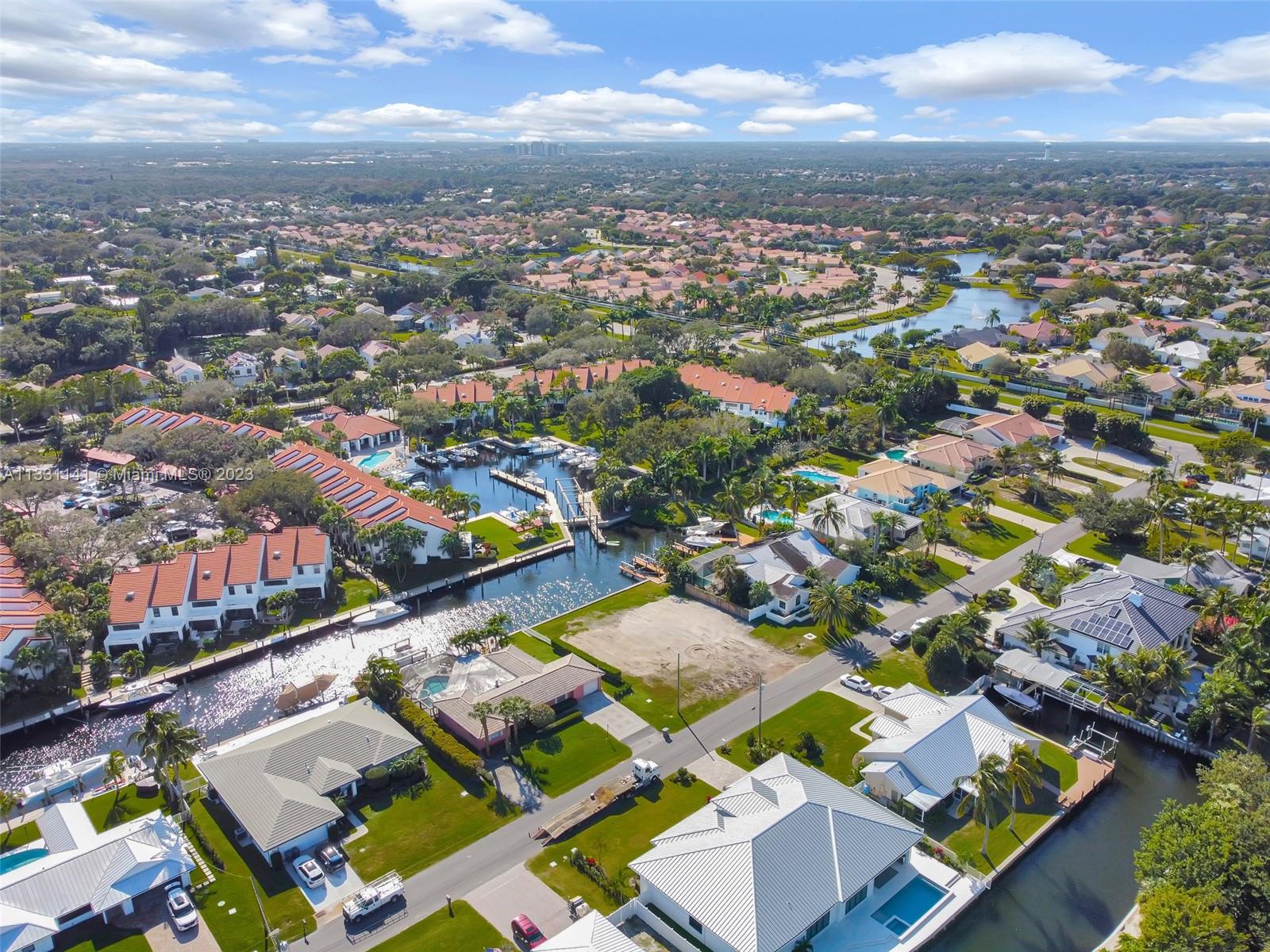 An aerial view shows residential homes, a canal with boat slips, and surrounding neighborhood landscaping — 2400 Edward Rd, Palm Beach Gardens FL 33410, PALM BEACH GARDENS, FL