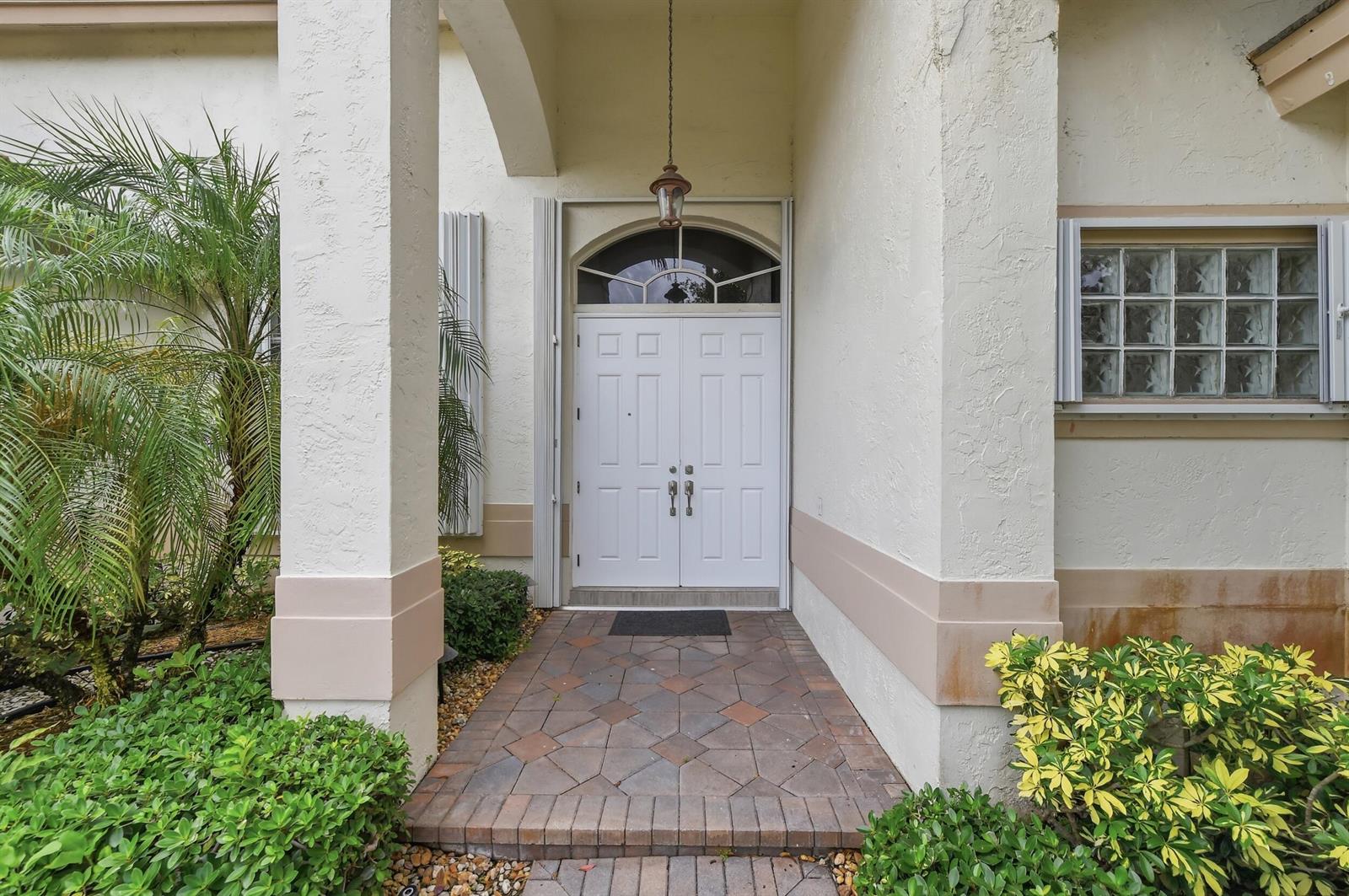 A white double front door with an arched transom window sits under a covered entryway — 2644 Miller Court, Weston FL 33332, WESTON, FL