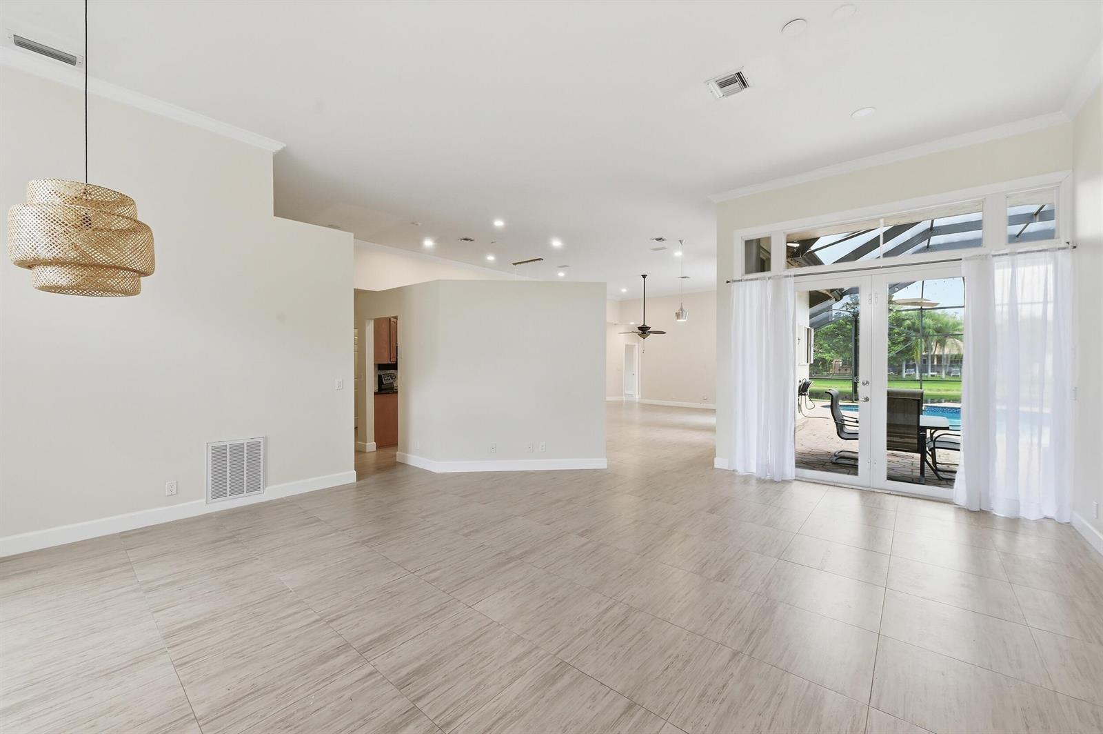 An open-concept living area features light tile flooring, a woven pendant light, and glass doors — 2644 Miller Court, Weston FL 33332, WESTON, FL