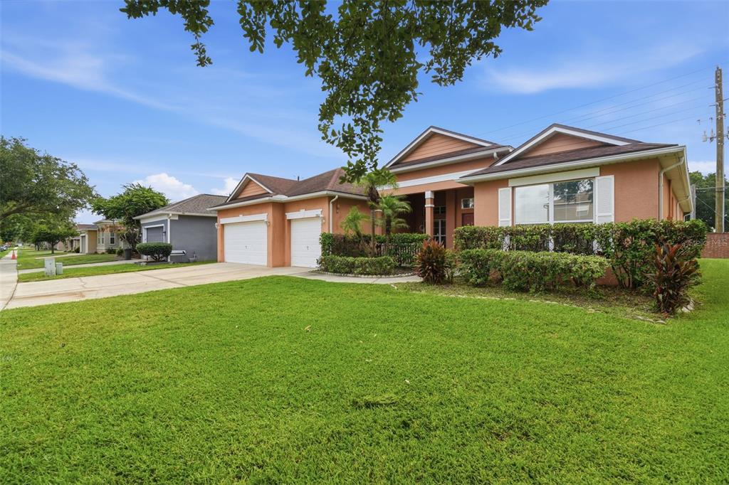 A single-story peach-colored house with a two-car garage and a manicured front lawn — 13618 OLD DOCK ROAD, ORLANDO, FL