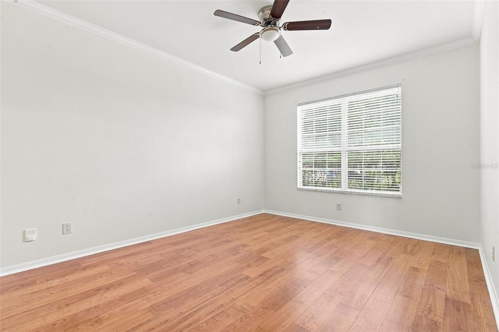 An empty bedroom features light gray walls, wood-look flooring, a ceiling fan, and a window — 13618 OLD DOCK ROAD, ORLANDO, FL