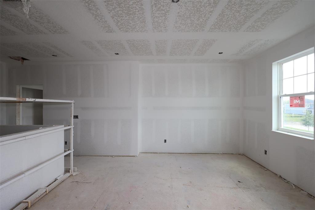 An unfinished room features white walls, three windows, and a kitchen island base — 6741 YELLOW WARBLER BEND, ST CLOUD, FL