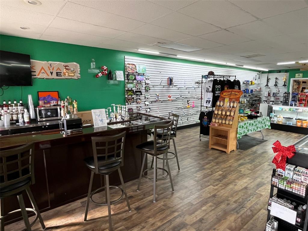 A retail shop interior features a service counter, bar stools, and wall-mounted product displays — 5915 MEMORIAL HIGHWAY, TAMPA, FL