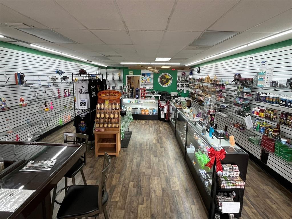 A retail smoke shop features slatwall shelving, glass display cases, and wood-look flooring — 5915 MEMORIAL HIGHWAY, TAMPA, FL