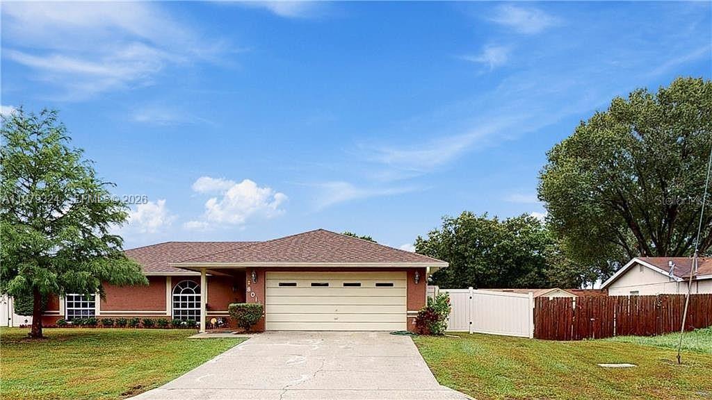 A single-story brick house features a two-car garage and a large front lawn — 8016 APACHE LN, Lakeland FL 33810, LAKELAND, FL