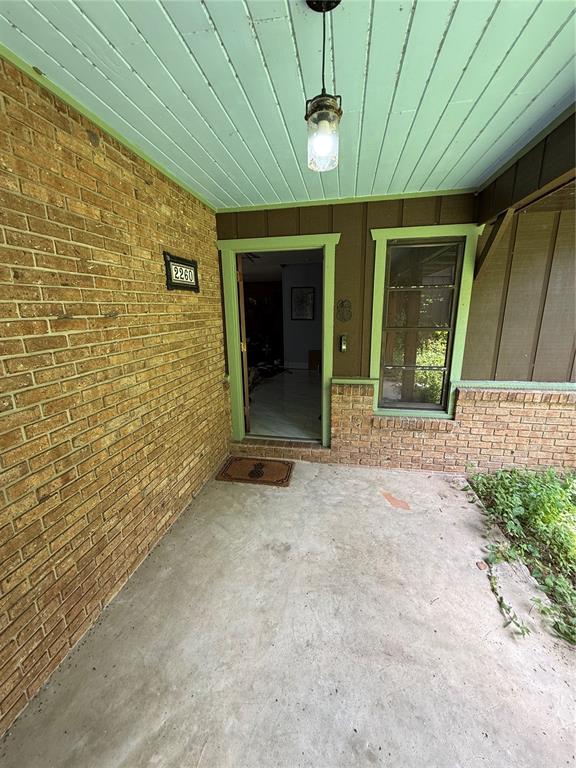 A covered brick porch features a light blue ceiling, a hanging lantern, and an open doorway — 2260 HONTOON ROAD, DELAND, FL