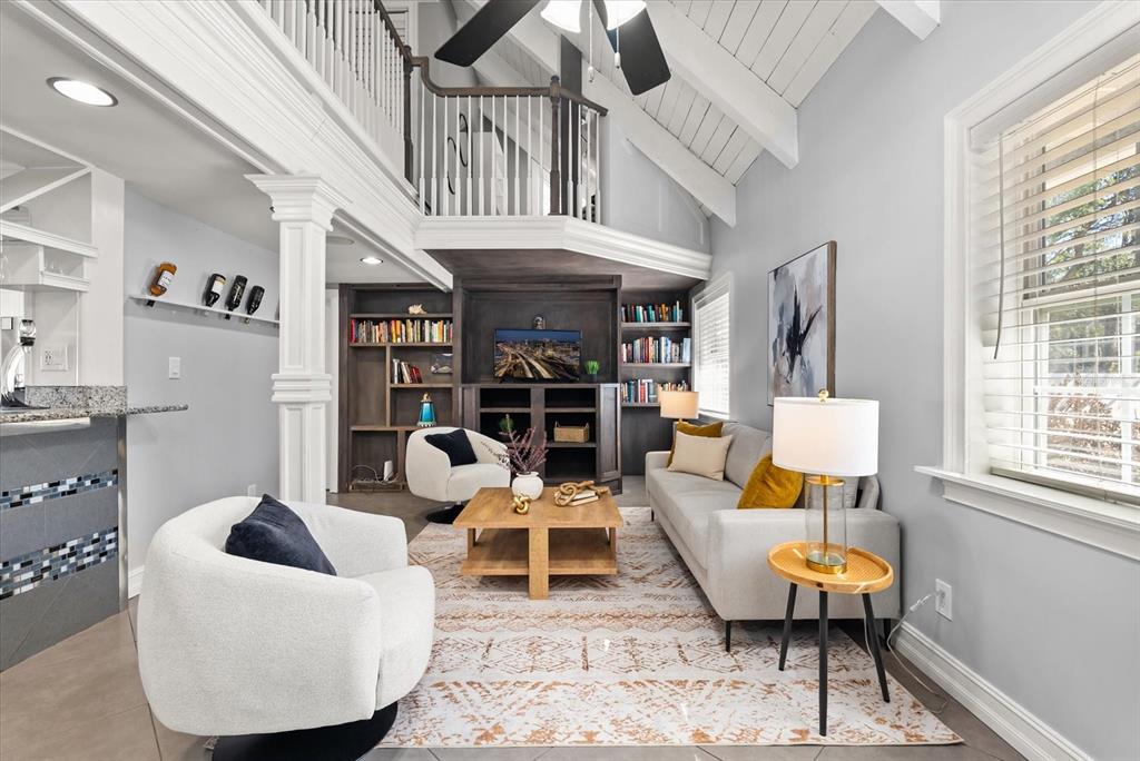 A living room features a vaulted ceiling, a lofted balcony, and built-in wooden shelving — 8255 LAKE UNDERHILL ROAD, ORLANDO, FL