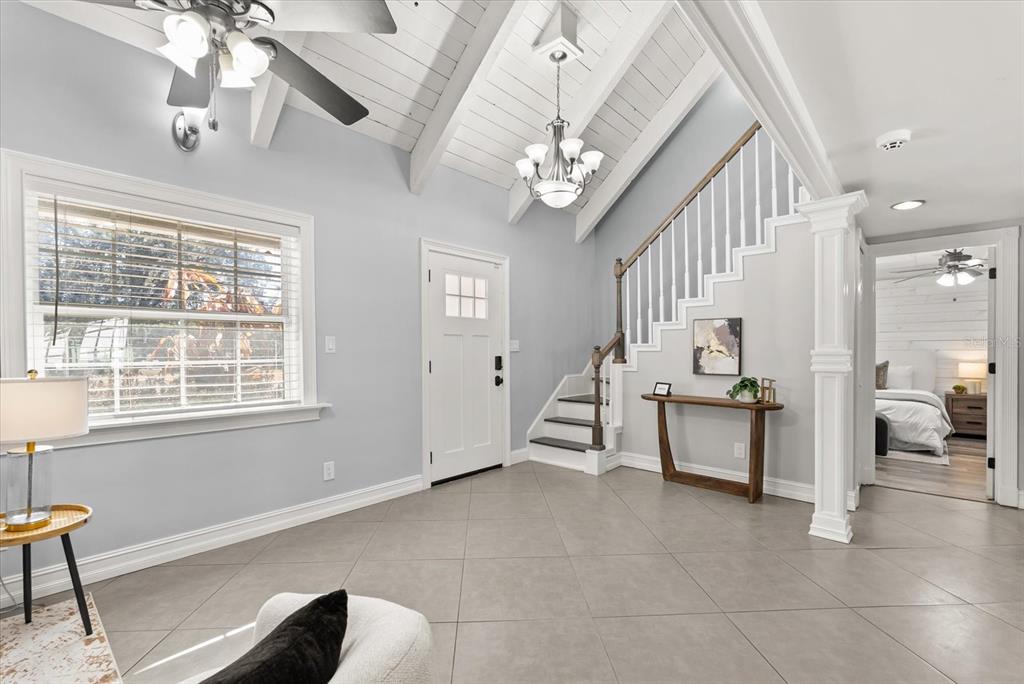 An entryway features a vaulted ceiling, tile flooring, a staircase, and a view into a bedroom — 8255 LAKE UNDERHILL ROAD, ORLANDO, FL