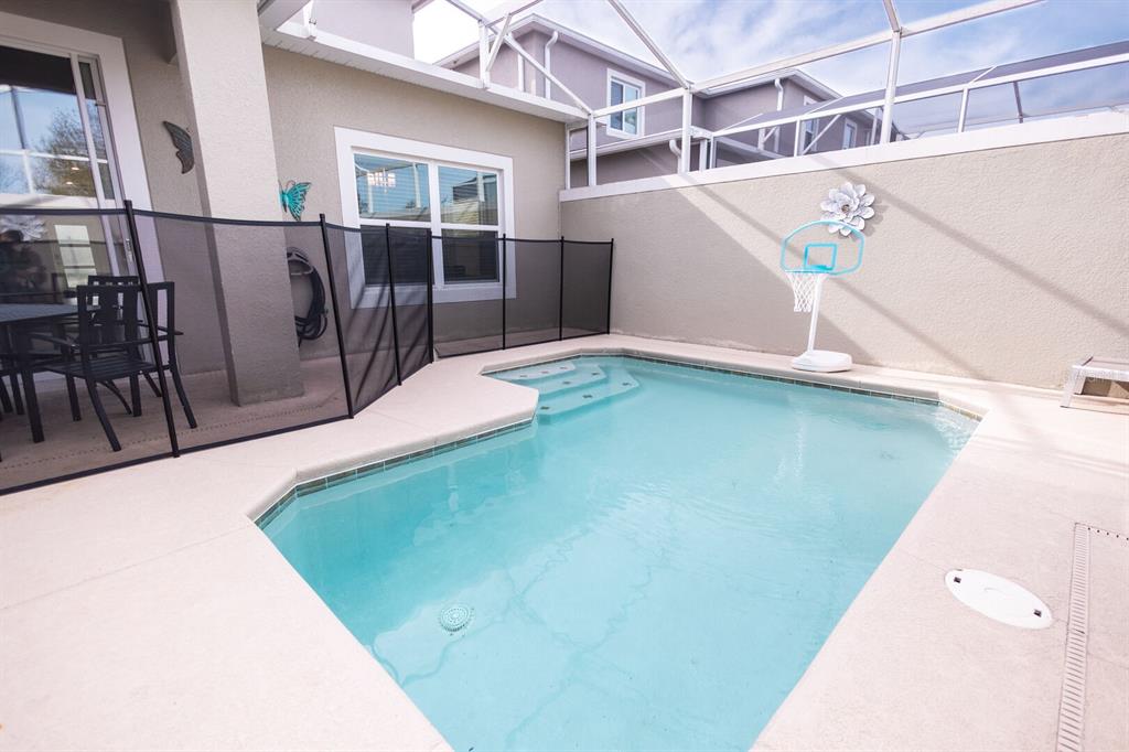 A screened-in patio features a small swimming pool, a basketball hoop, and a safety fence — 8967 CABOT CLIFFS DRIVE, KISSIMMEE, FL