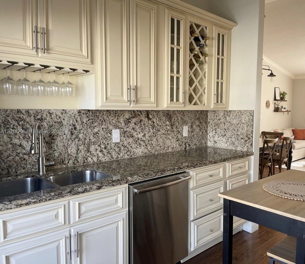 A kitchen features cream-colored cabinets, granite countertops, a stainless steel dishwasher, and a wine rack — 7100 NW 173rd Dr # 1304, Hialeah FL 33015, HIALEAH, FL