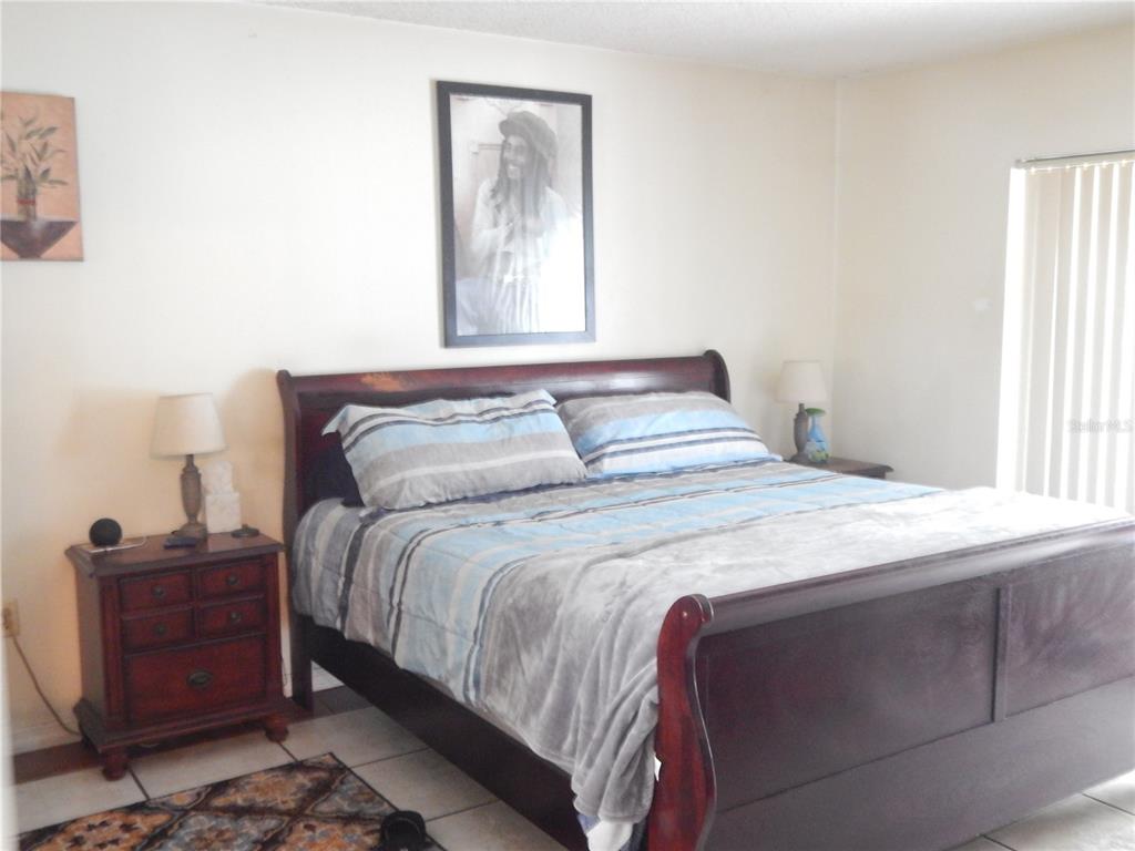 A bedroom features a dark wood sleigh bed, two nightstands, and a framed wall portrait — 4109 CANNON COURT, KISSIMMEE, FL