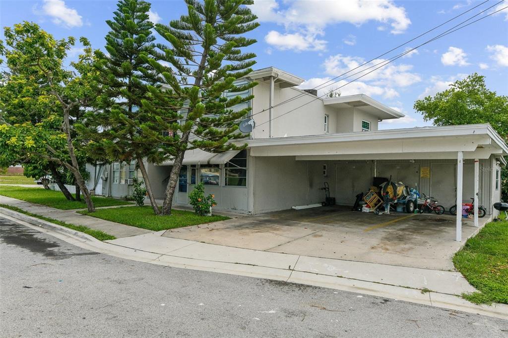 A two-story building with a covered carport and tall pine trees in the front yard — 1267 FRANKLIN STREET, CLEARWATER, FL