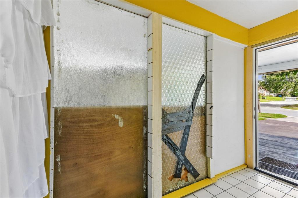 A room with white walls, a lime green accent wall, dining area, and exercise equipment — 1267 FRANKLIN STREET, CLEARWATER, FL