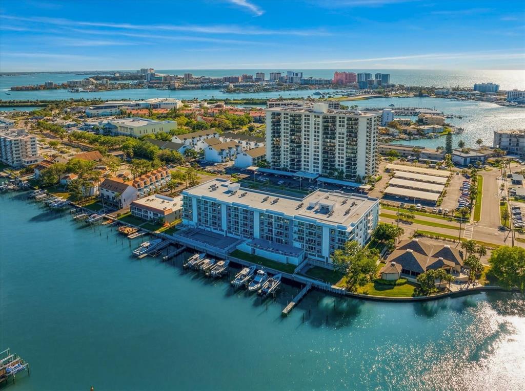 An aerial view of a waterfront condominium complex with boat slips and a swimming pool — 125 ISLAND WAY UNIT 402, CLEARWATER BEACH, FL