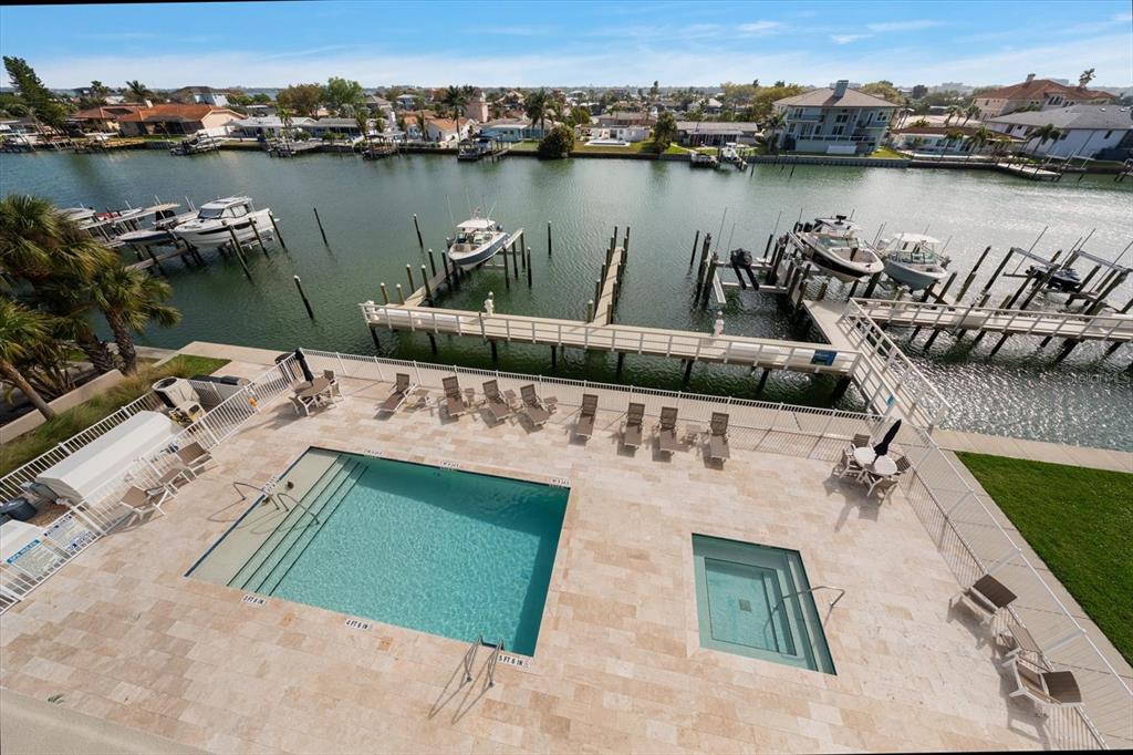 An elevated view of a swimming pool, hot tub, and boat docks on a canal — 125 ISLAND WAY UNIT 402, CLEARWATER BEACH, FL