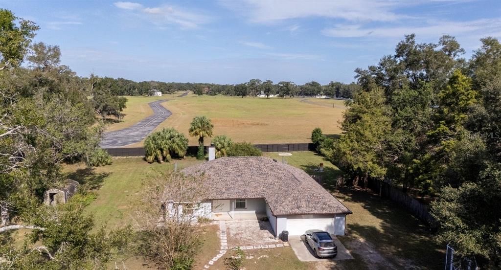 An aerial view of a single-story house with a shingled roof and a paved driveway — 1801 NE 77TH STREET, OCALA, FL