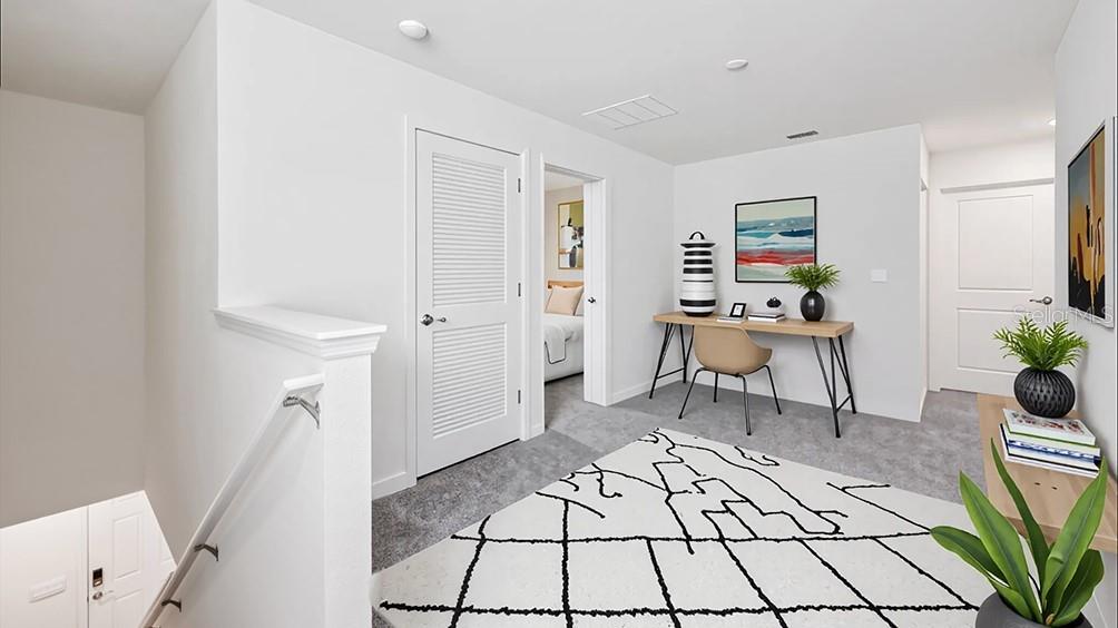 A carpeted landing area features a desk, a patterned rug, and a doorway to a bedroom — 10590 TUCKER ROAD, WEEKI WACHEE, FL