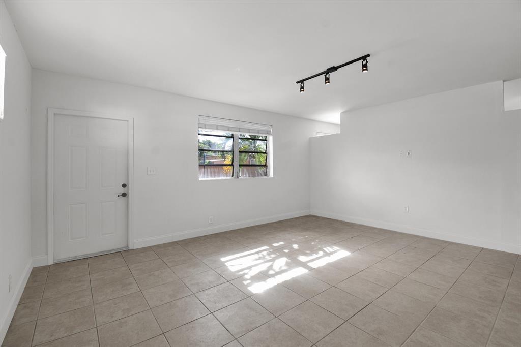 An empty room with white walls, tile flooring, a window, and track lighting — 1116 S 17th Avenue S, Hollywood FL 33020, HOLLYWOOD, FL