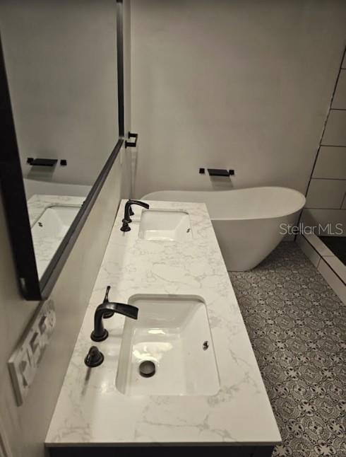 A bathroom features a double vanity with a marble countertop and a freestanding soaking tub — 319 W WEST STREET, TAMPA, FL