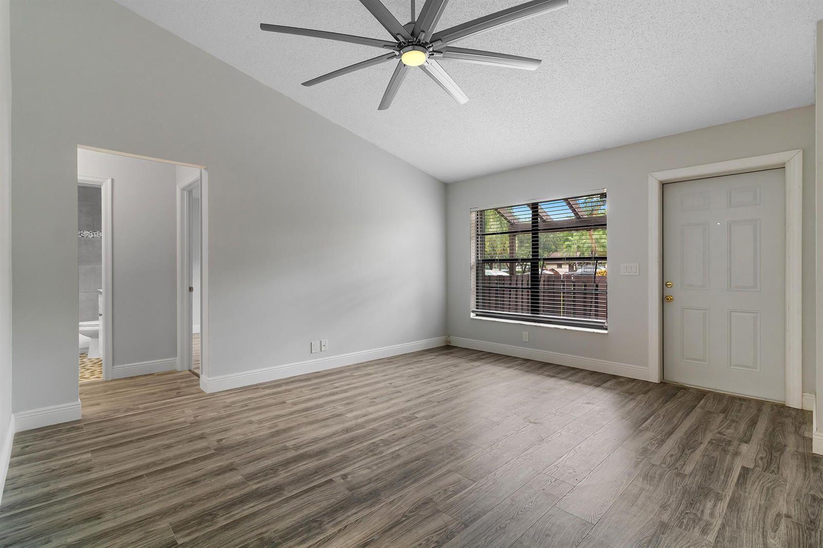 A room with light gray walls, wood-look flooring, a ceiling fan, and a single door — 9 Vía De Casas Norte, Boynton Beach FL 33426, BOYNTON BEACH, FL