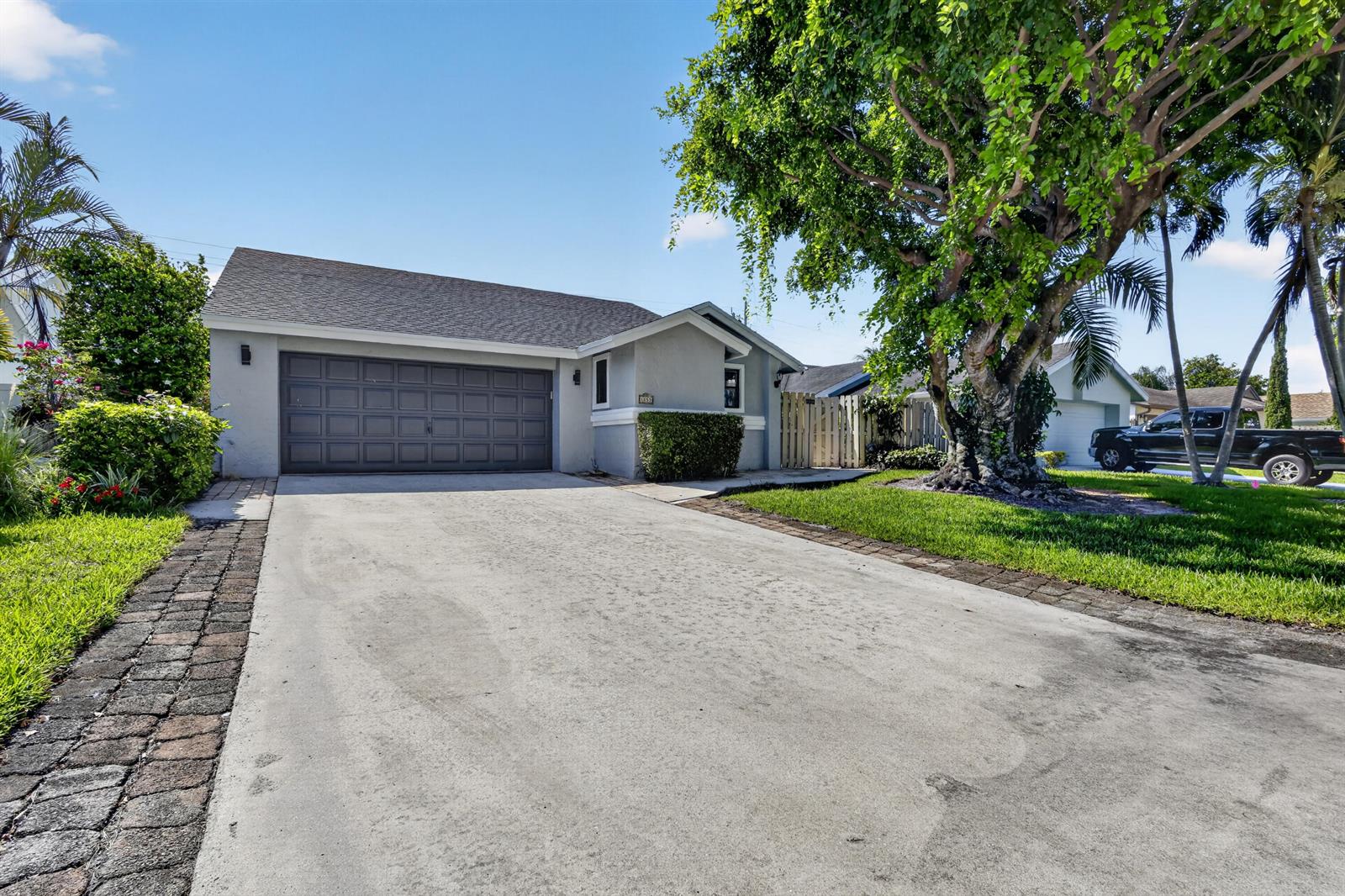 A single-story house with a gray exterior, a two-car garage, and a large tree — 1055 NW 18th Avenue, Delray Beach FL 33445, DELRAY BEACH, FL