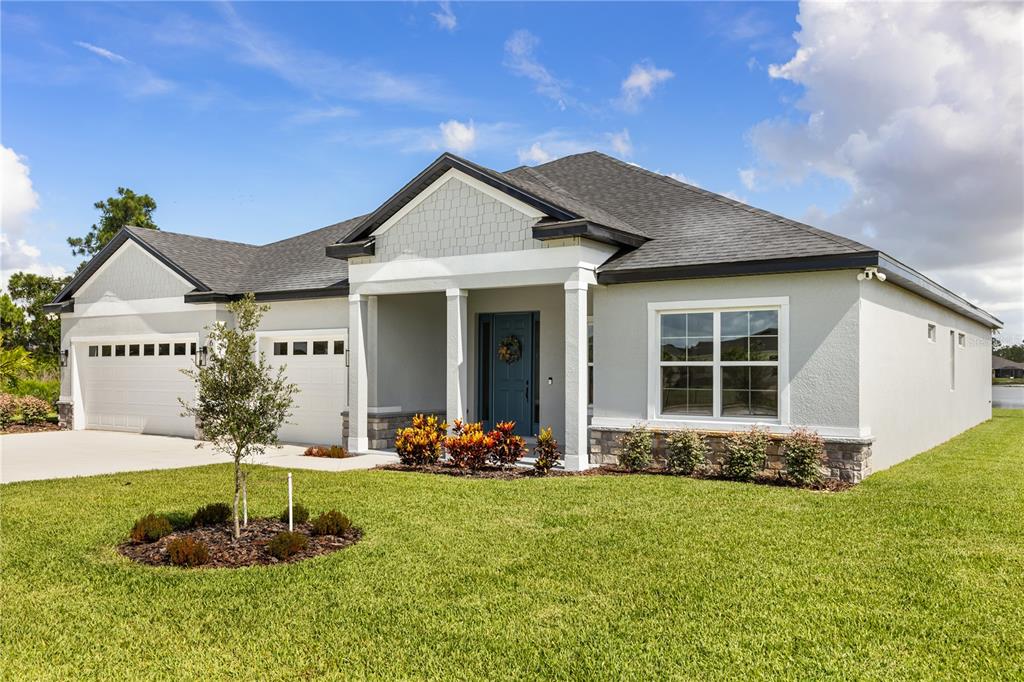 A single-story house with a light gray exterior, a two-car garage, and a covered entryway — 6400 SUN N LAKE BOULEVARD, SEBRING, FL