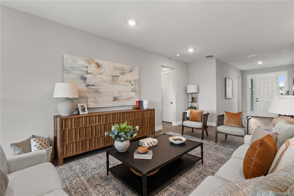 A living room features a wooden console table, a black coffee table, and two armchairs — 6400 SUN N LAKE BOULEVARD, SEBRING, FL