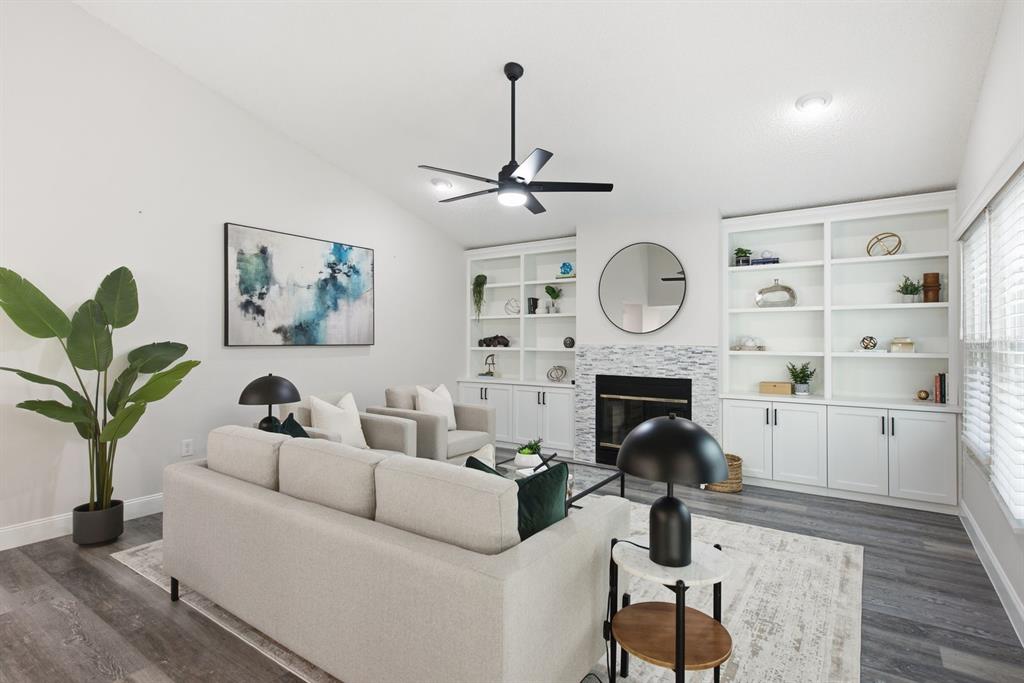 A living room features a fireplace with built-in shelving, a sofa, and a ceiling fan — 2767 VANESSA LANE, PALM HARBOR, FL