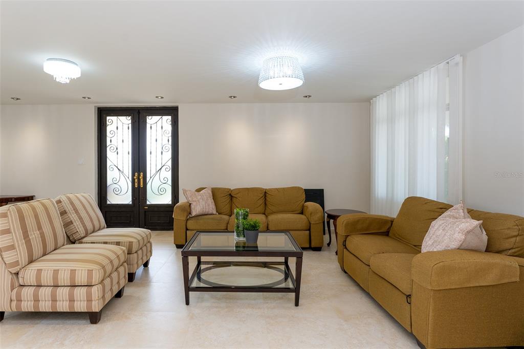 A living room features a brown sofa, two striped chairs, and a glass coffee table — 254 SABANERA, DORADO, PR