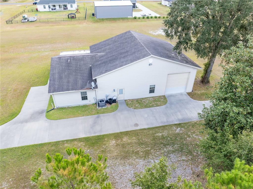 An aerial view of a white house with a garage and a concrete driveway — 168 SW POBEREZNY GLN, LAKE CITY, FL