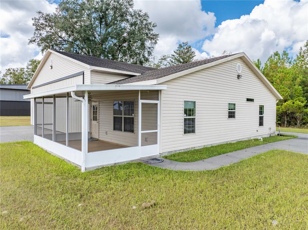 A light-colored house with a screened-in porch and a concrete walkway on a grassy lot — 168 SW POBEREZNY GLN, LAKE CITY, FL