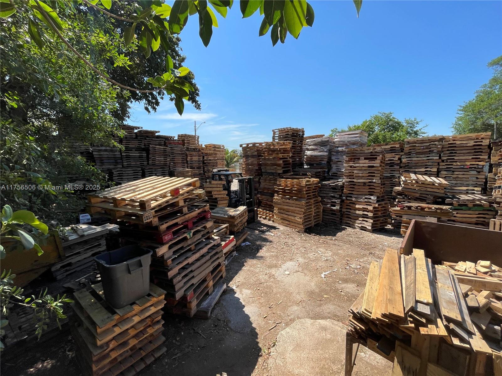 An outdoor storage area is filled with numerous stacks of wooden shipping pallets — 3013 NW 54th St, Miami FL 33142, MIAMI, FL